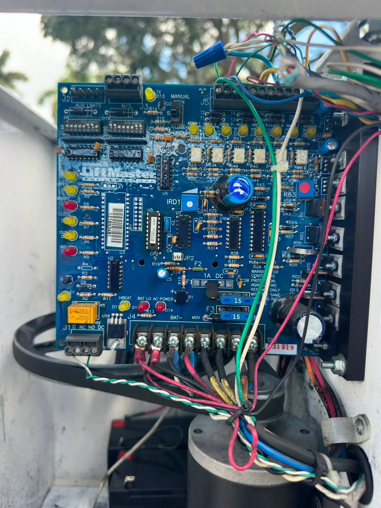 Blue gate operator control board with terminals, wiring and adjustment controls inside its cabinet