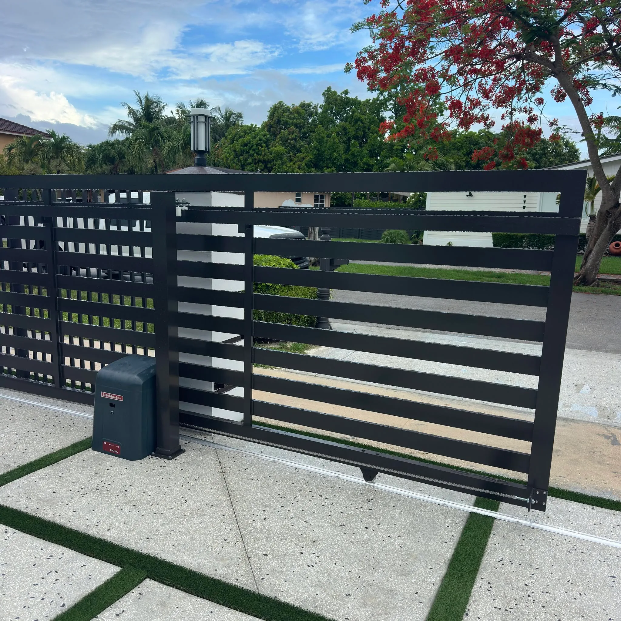 Black sliding driveway gate with a LiftMaster operator installed beside its track